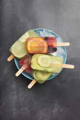 Various fruit popsicles on bowl with ice cubes - SKCF00340