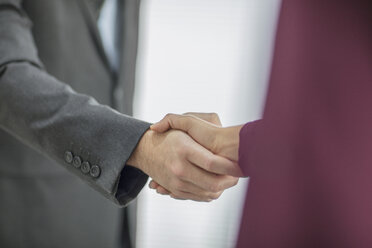 Close-up of businessman and businesswoman shaking hands - ZEF15037