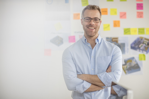 Porträt eines lächelnden Geschäftsmannes im Büro, lizenzfreies Stockfoto