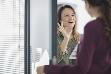 Zwei Geschäftsfrauen mit Tablet im Gespräch im Büro - ZEF15045