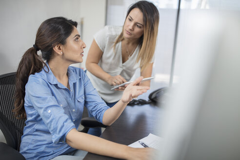 Zwei Geschäftsfrauen im Gespräch am Schreibtisch im Büro - ZEF15067