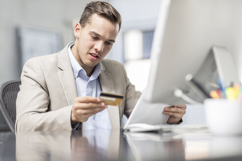 Geschäftsmann beim Online-Shopping am Schreibtisch im Büro - ZEF15080