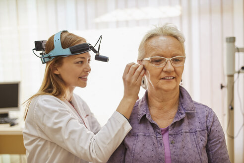 ENT physician examining ear of a senior woman - ZEDF01230
