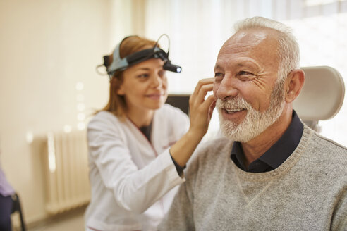 ENT physician examining ear of a senior man - ZEDF01232