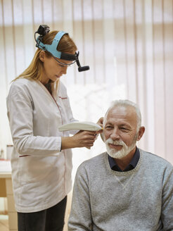 ENT physician examining ear of a senior man - ZEDF01235