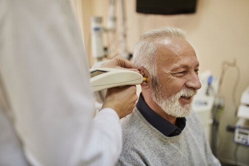 ENT physician examining ear of a senior man - ZEDF01236