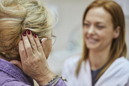 Female doctor and senior woman with hearing aid - ZEDF01251