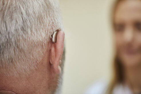 Female doctor and senior man with hearing aid - ZEDF01252