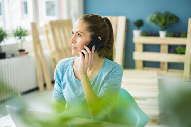 Woman talking on the phone in her new home - MOEF00908