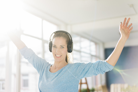 Porträt einer schönen Frau, die mit Kopfhörern Musik hört, lizenzfreies Stockfoto