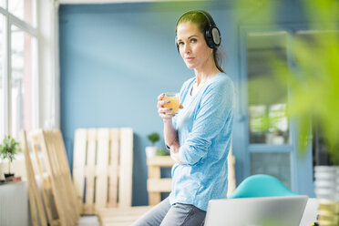 Woman refurbishing her new home, taking a break, drinking coffee and listening music - MOEF00913