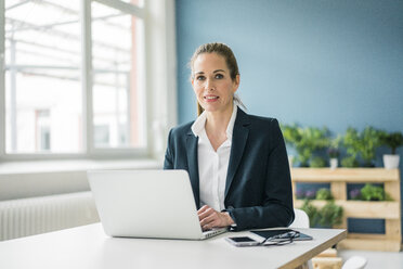 Confident business woman sitting at desk stock photo (135604