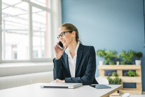 Geschäftsfrau, die von zu Hause aus arbeitet und telefoniert - MOEF00918