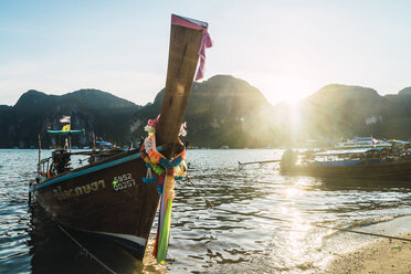 Thailand, Phi Phi Inseln, Ko Phi Phi, vertäutes Longtailboot im Gegenlicht - KKAF00875