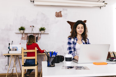 Modedesigner mit Laptop im Atelier - JRFF01562