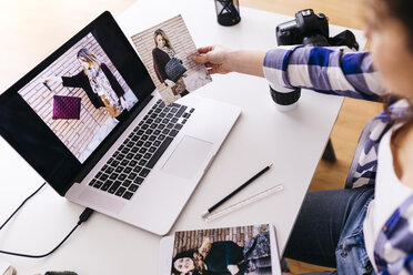 Modedesigner mit Laptop beim Betrachten von Fotos im Atelier - JRFF01572