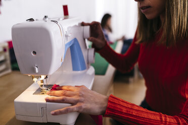 Modedesignerin im Atelier an der Nähmaschine - JRFF01592