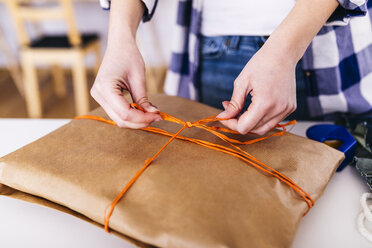 Nahaufnahme einer Frau beim Einpacken eines Pakets - JRFF01599