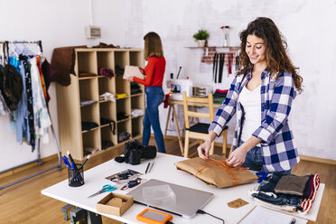 Modedesigner beim Einpacken eines Pakets im Atelier - JRFF01600