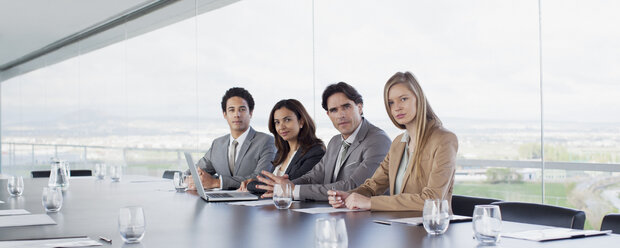 Porträt von zuversichtlichen Geschäftsleuten am Tisch im Konferenzraum - CAIF00018