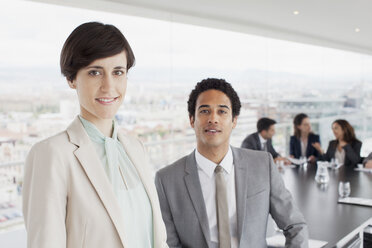 Porträt eines lächelnden Geschäftsmannes und einer Geschäftsfrau in einem Konferenzraum - CAIF00025