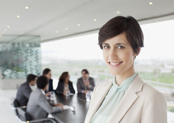 Porträt einer lächelnden Geschäftsfrau im Konferenzraum - CAIF00028