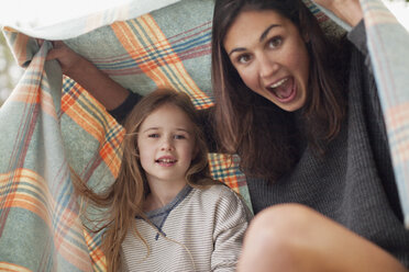 Enthusiastic mother and daughter under blanket - CAIF00101