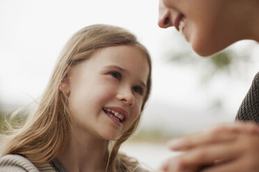 Close up of smiling daughter looking up at mother - CAIF00110