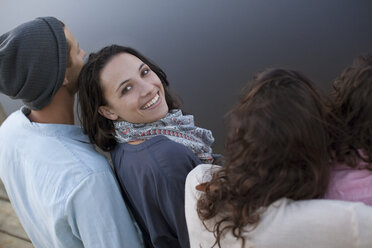 Portrait of smiling woman sitting with friends at lake - CAIF00123