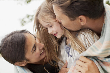 Nahaufnahme einer glücklichen Familie, eingewickelt in eine Decke - CAIF00148