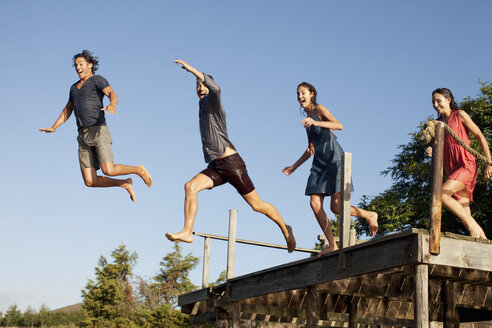 Enthusiastische Freunde springen vom Steg - CAIF00162