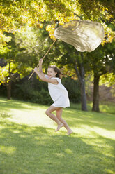 Happy girl on the beach running with a butterfly net stock photo