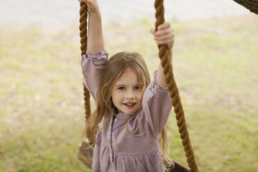 Portrait of smiling girl on swing - CAIF00199