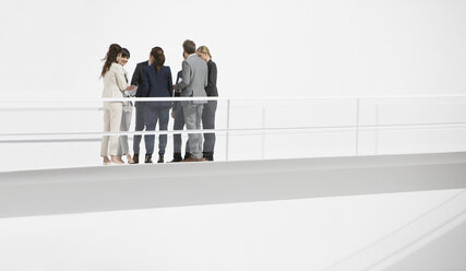 Business people meeting on elevated walkway - CAIF00214