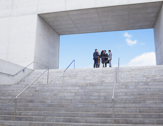 Geschäftsleute treffen sich an der Spitze einer städtischen Treppe - CAIF00244