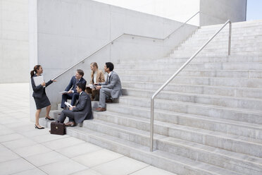 Business people meeting on urban stairs - CAIF00256