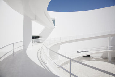 Businessman ascending curving elevated walkway - CAIF00284