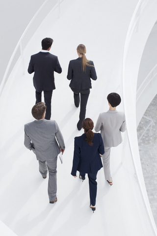 Geschäftsleute, die einen erhöhten Gehweg besteigen, lizenzfreies Stockfoto