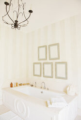 Chandelier over bathtub in luxury bathroom - CAIF00360