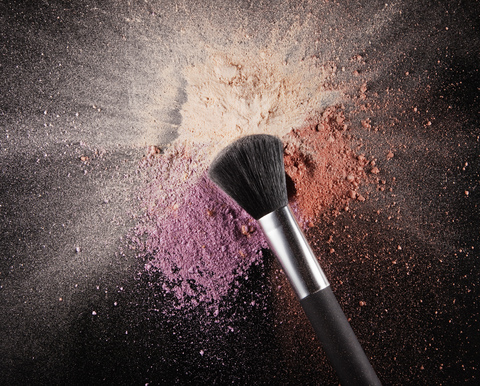 Make-up-Pinsel über mehrfarbigem Rouge-Splatter, lizenzfreies Stockfoto