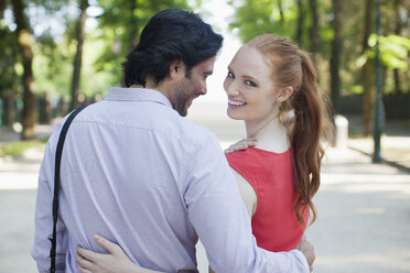 Portrait of smiling woman walking with boyfriend in park - CAIF00479