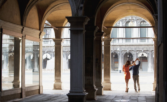 Paar tanzt im Torbogen in Venedig - CAIF00530