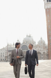Lächelnde Geschäftsleute beim Spaziergang über den Markusplatz in Venedig - CAIF00562