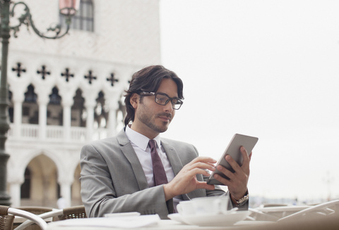 Geschäftsmann mit digitalem Tablet in einem Straßencafé in Venedig, lizenzfreies Stockfoto
