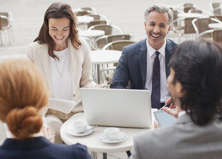 Lachende Geschäftsleute treffen sich in einem Straßencafé - CAIF00610