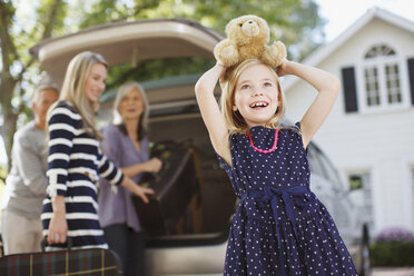 Girl carrying teddy bear on her head - CAIF00661