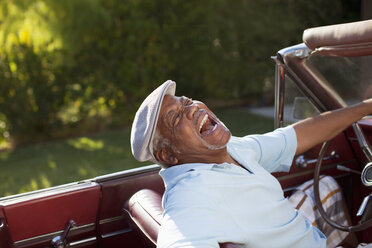 Lachender älterer Mann am Steuer eines Cabriolets - CAIF00678