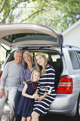 Family sitting in trunk of car - CAIF00701