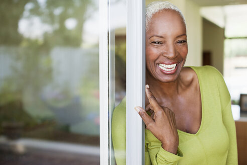 Ältere Frau lächelt in der Tür - CAIF00736