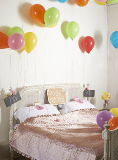 Bunte Luftballons über dem Ehebett - CAIF00760